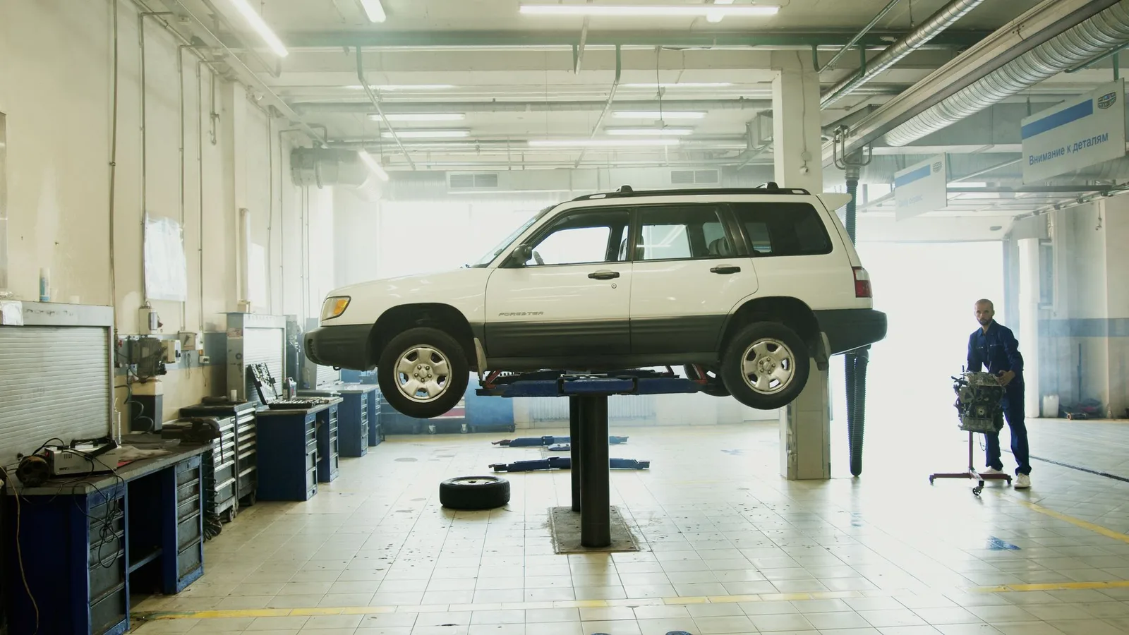 A technician beside a lifted vehicle in a service bay